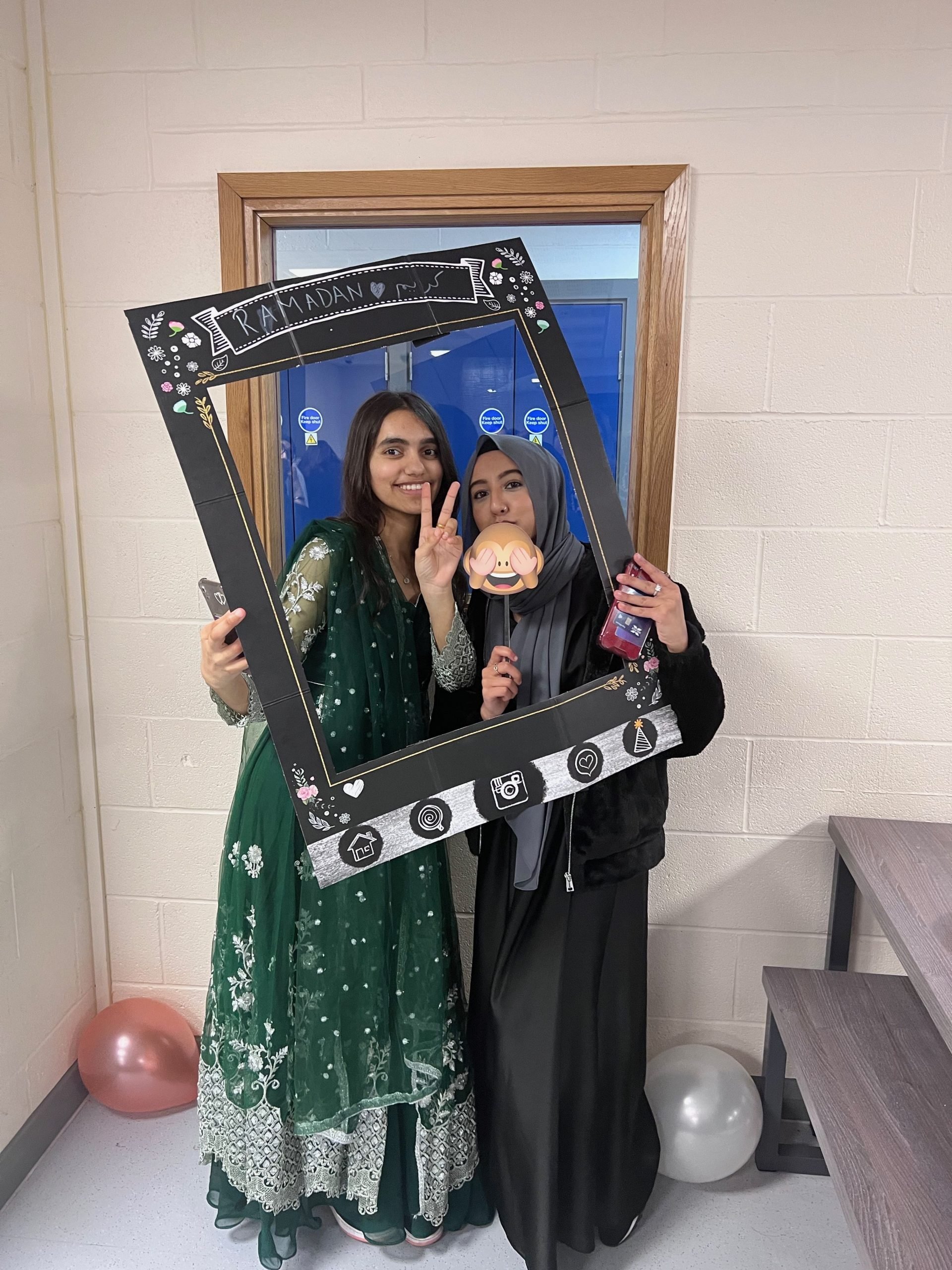 Two Loreto female students posting with a Instagram frame.