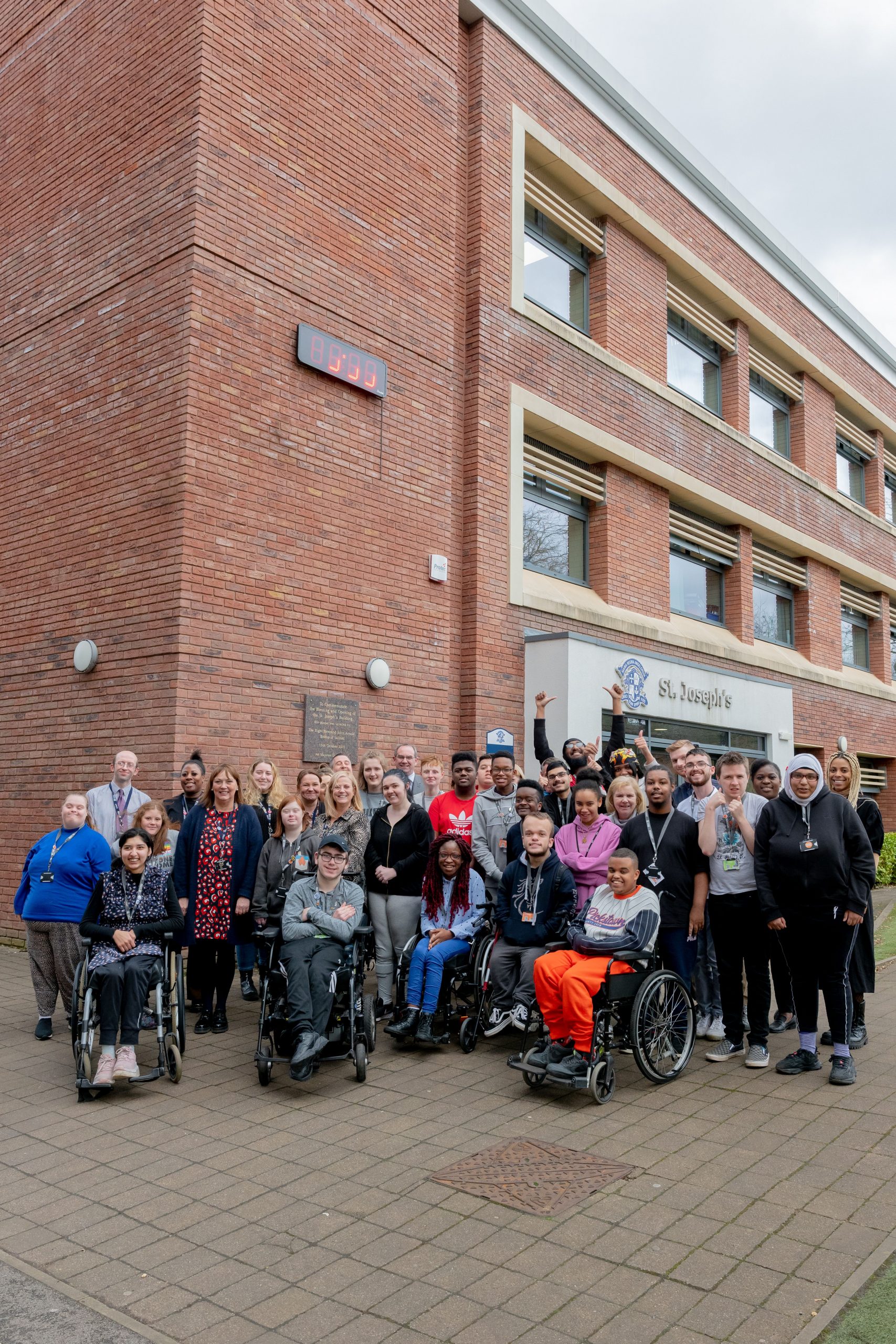 Pathways to Independence students and staff celebrating outside St Joseph's building at Loreto College.