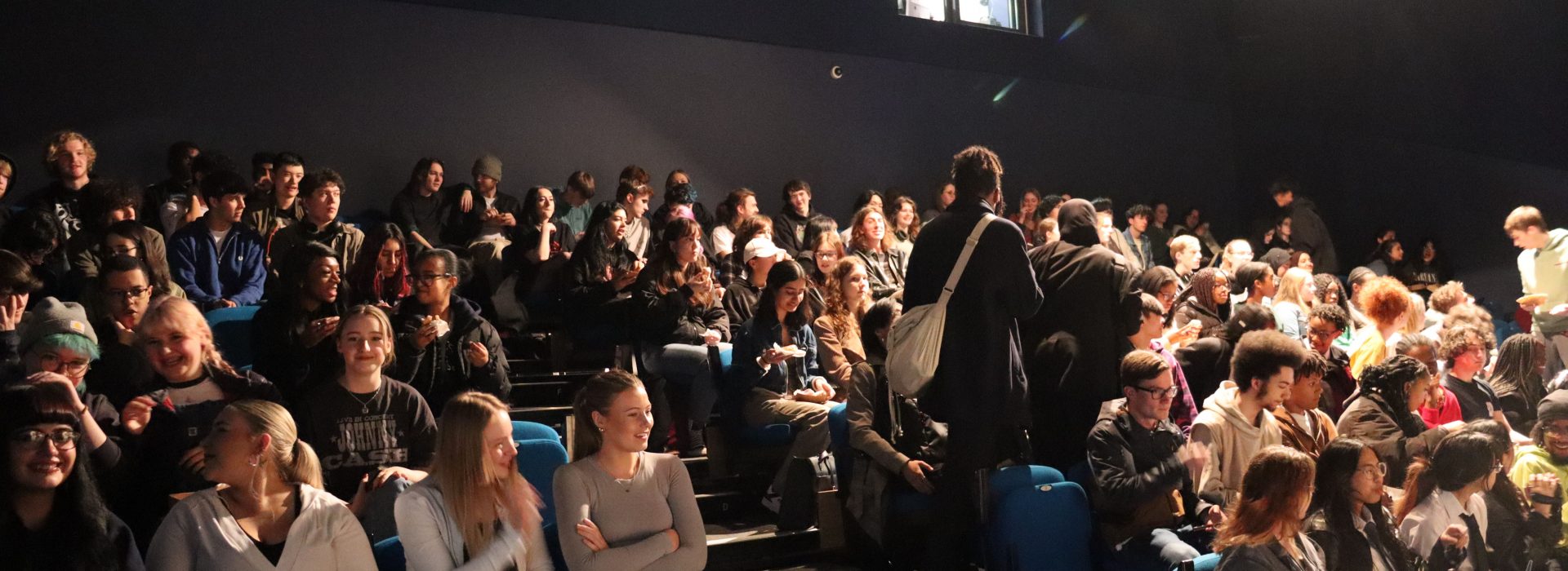 Students find their seats in the college theatre.