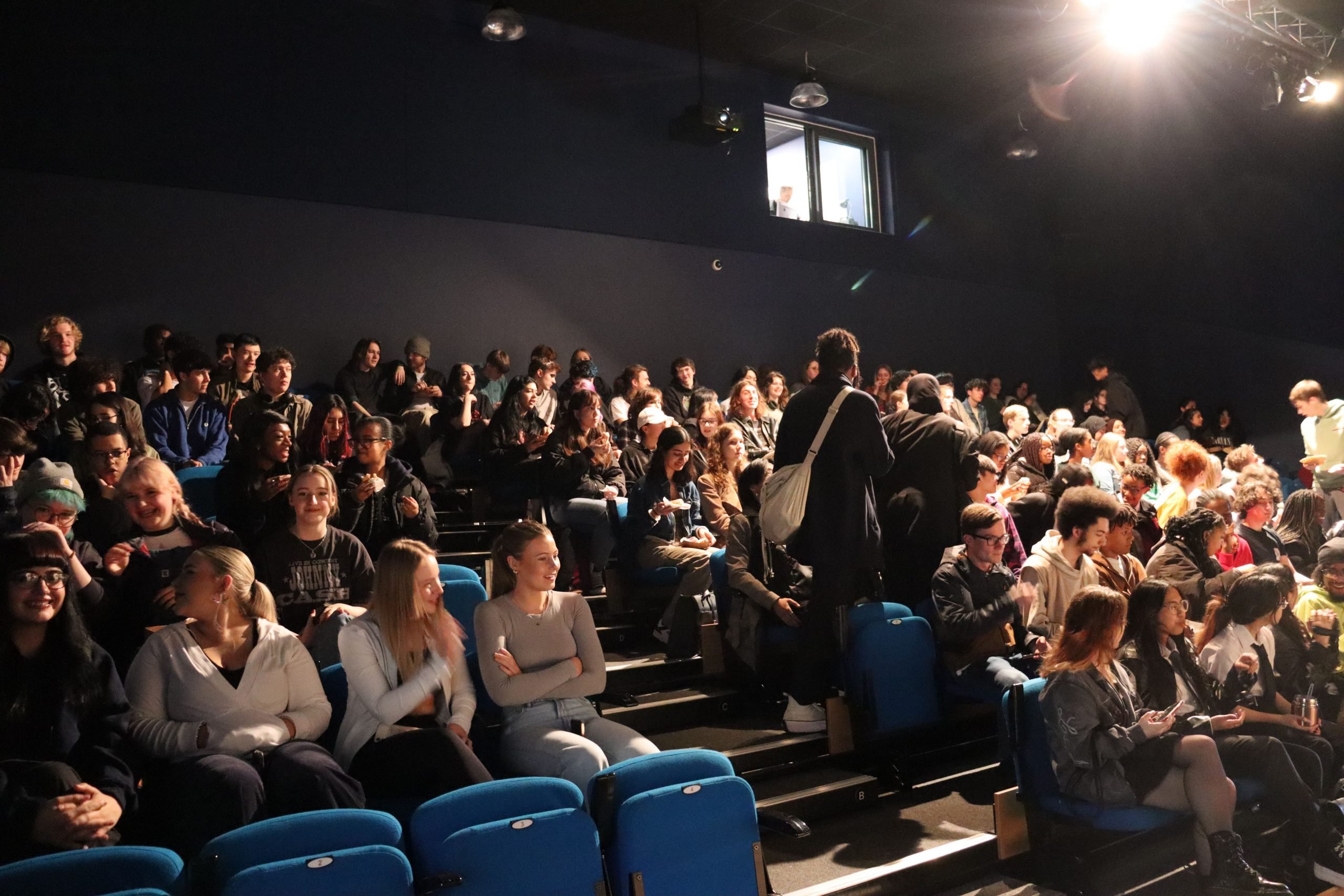 Students find their seats in the college theatre.