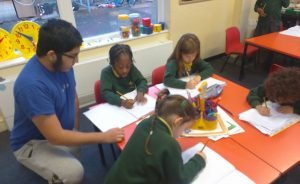 Student with helping 4 small children with their work.