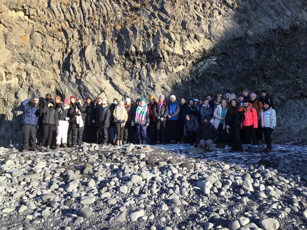 Loreto students pictured alongside a stratified rock formation in Iceland.