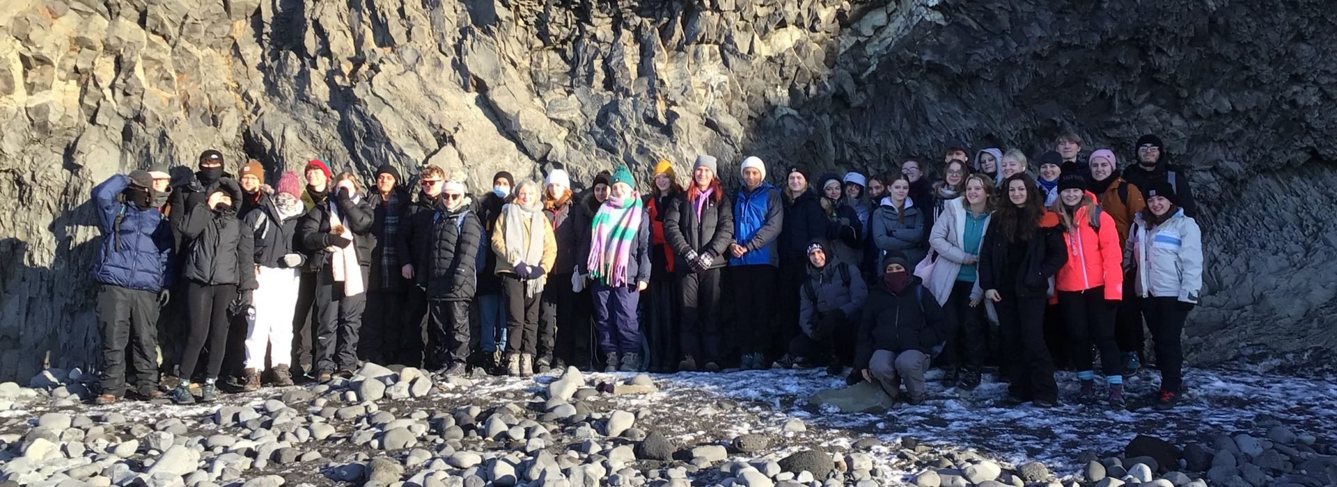 Loreto students pictured alongside a stratified rock formation in Iceland.
