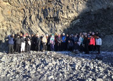Loreto students pictured alongside a stratified rock formation in Iceland.