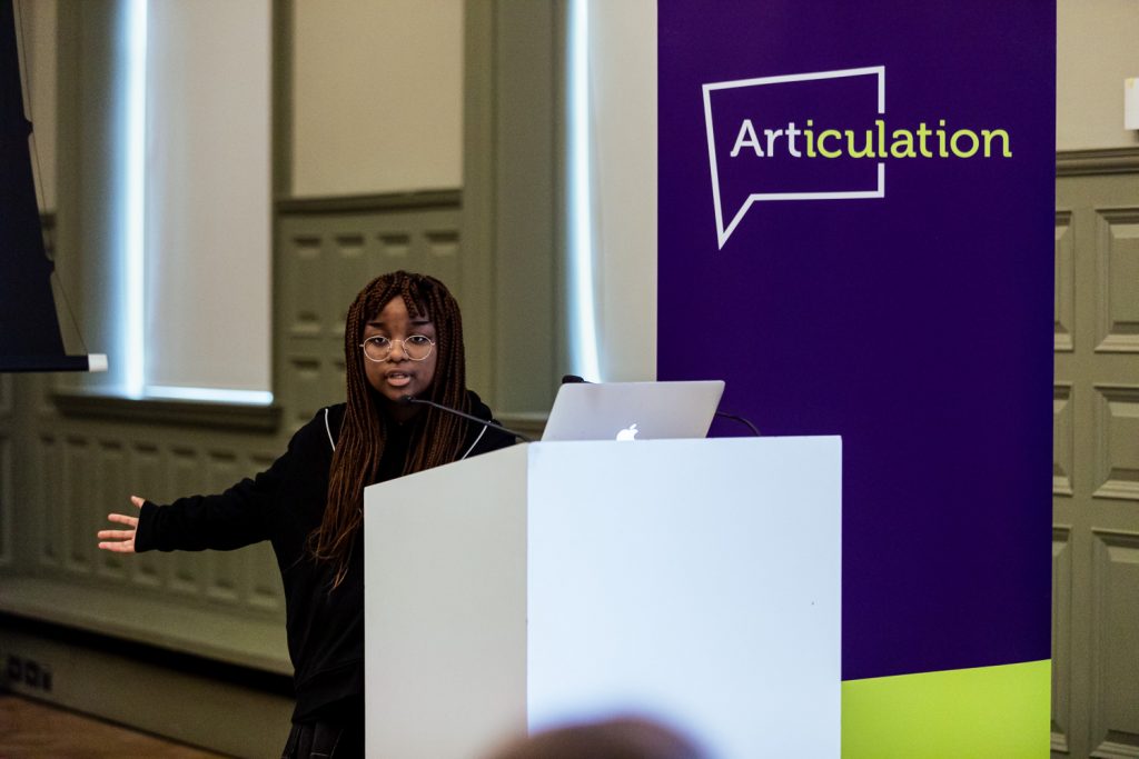 Young student giving a presentation from a lecturn.