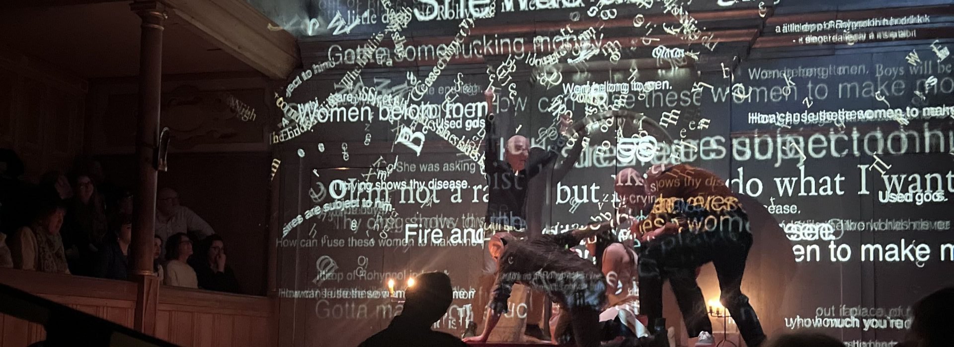 Words projected on to actors performing on the stage.