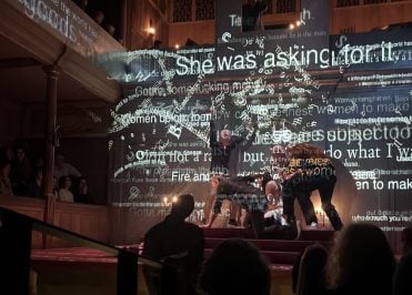 Words projected on to actors performing on the stage.