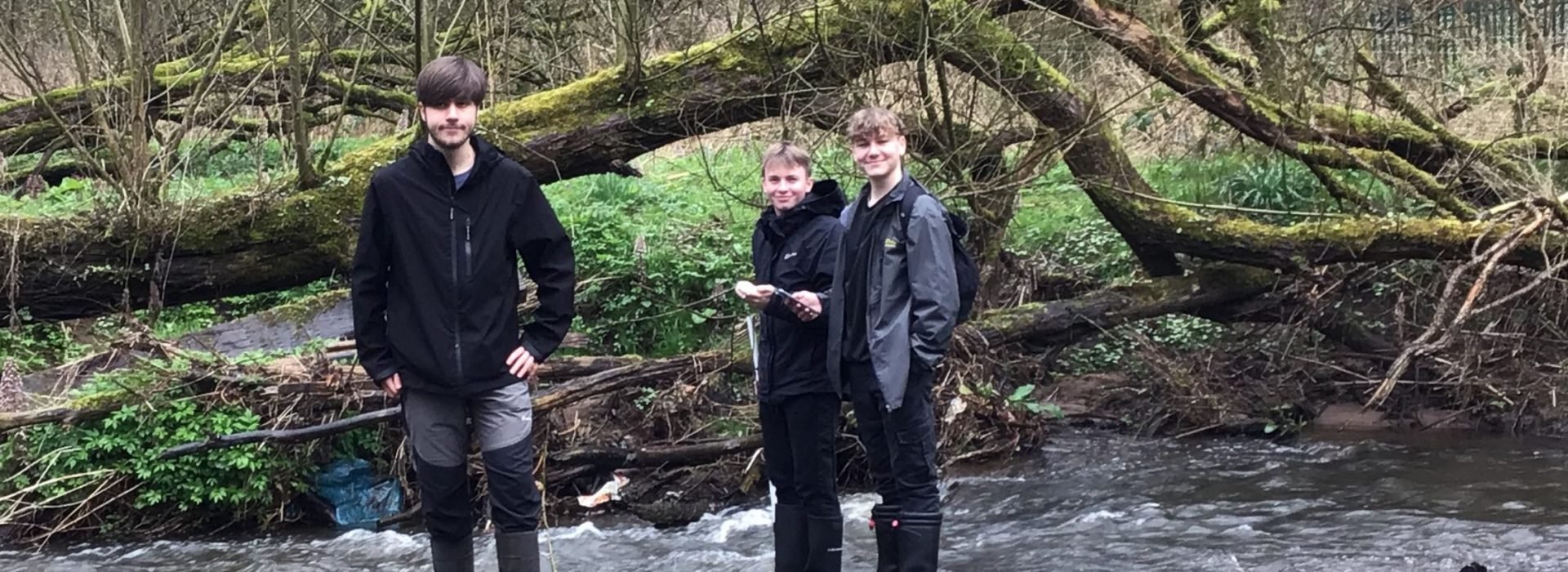 Three Loreto Geography students standing in the River Bollin in their wellington boots.