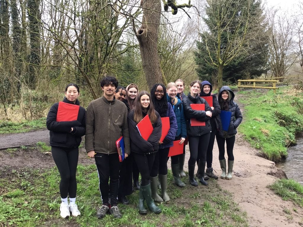 A small group of Loreto A Level Geography students dressed in wellies and holding red clip boards visiting Macclesfield Forest.