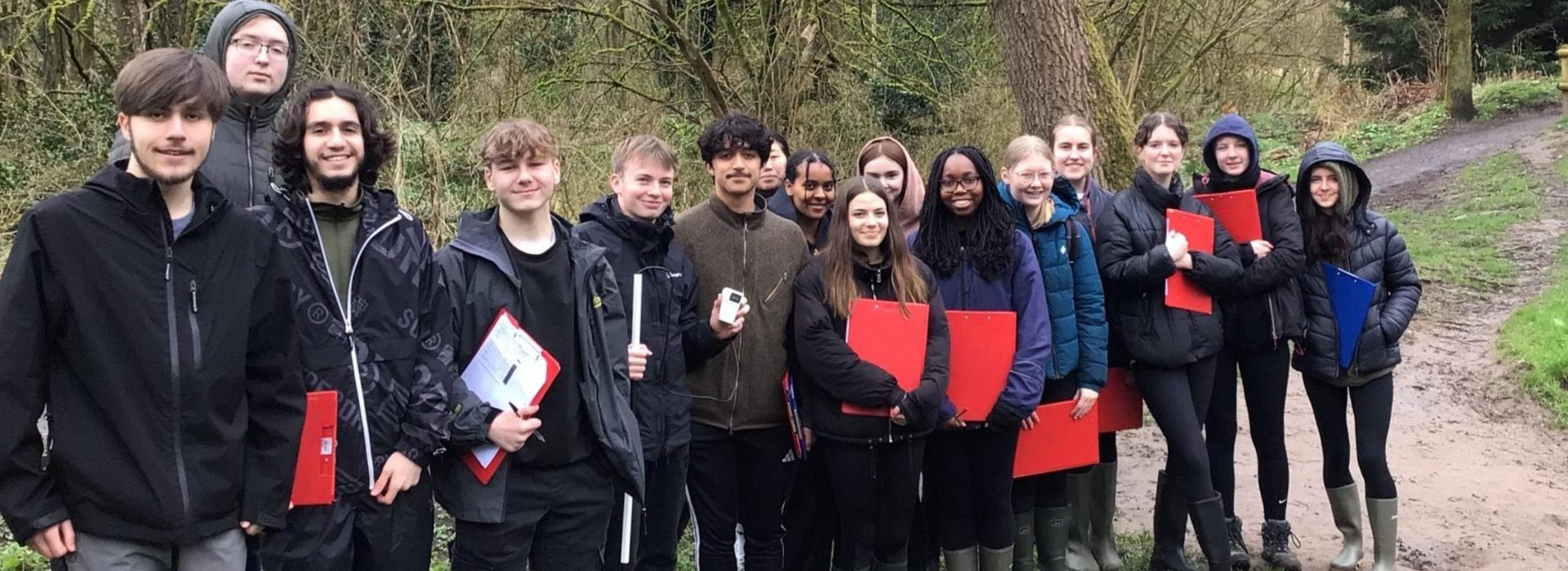 A large group of Loreto A Level Geography students dressed in wellies and holding red clip boards visiting Macclesfield Forest.