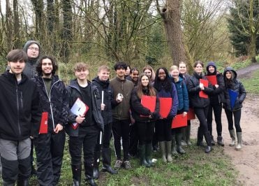 A large group of Loreto A Level Geography students dressed in wellies and holding red clip boards visiting Macclesfield Forest.