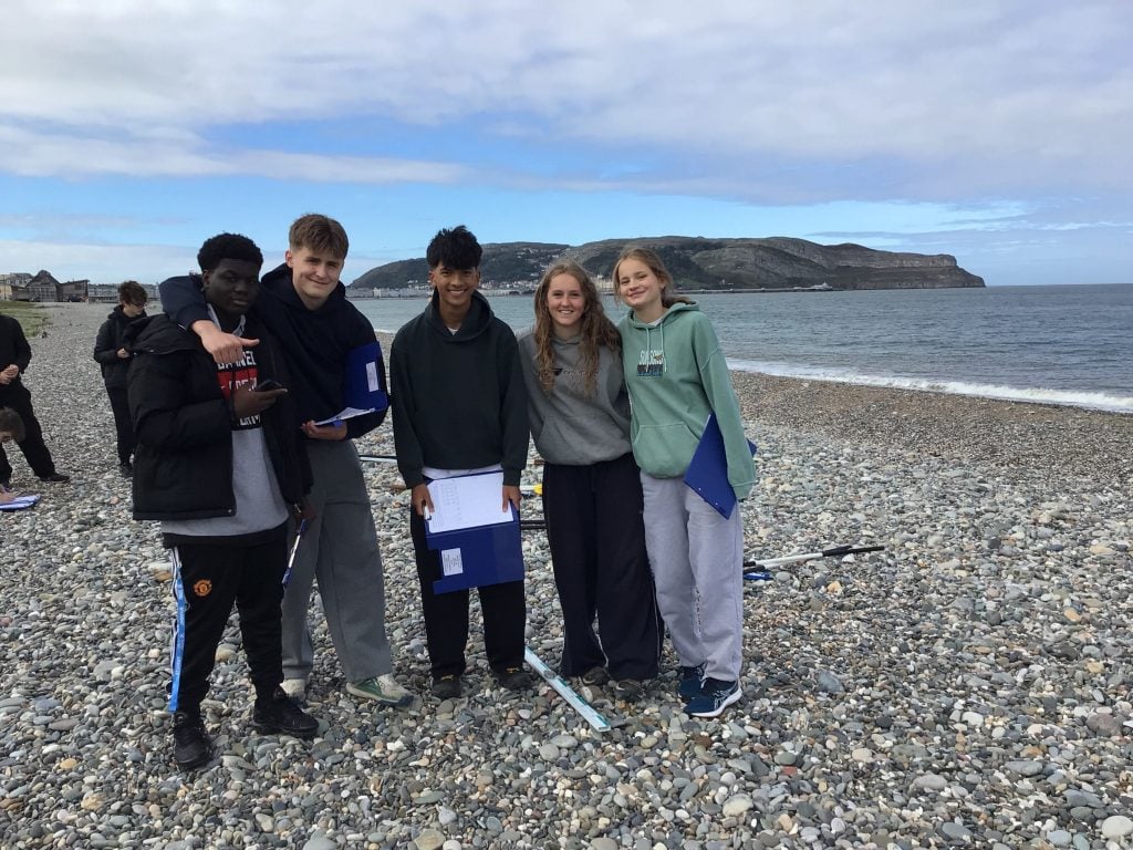 Small group of Loreto students on the pebbled beach in Llandudno.