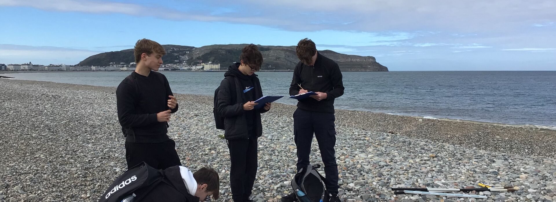 Small group of Loreto students on the pebbled beach in Llandudno.