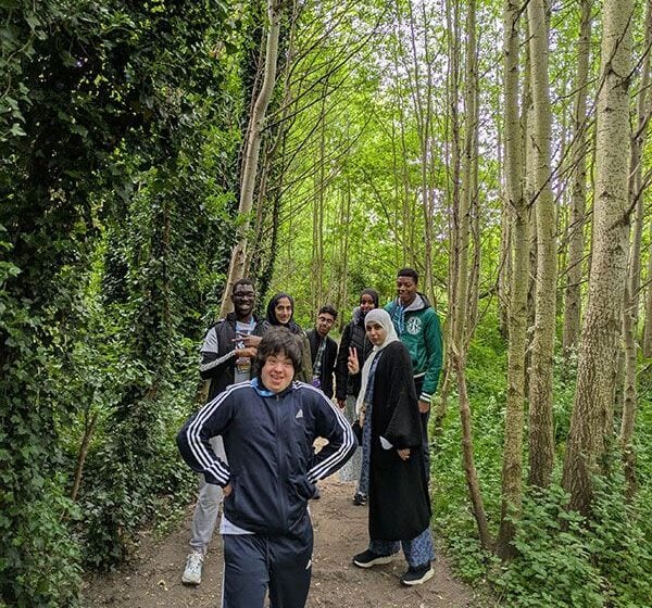7 young students walking a path in the woodlands.