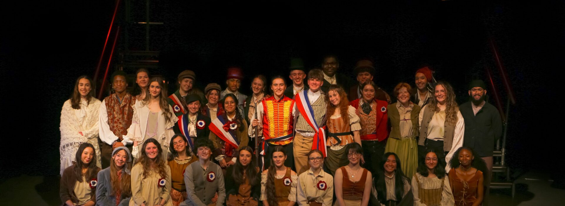 students from teh production dressed in costumes from 19th century france in the production of Les Miserables