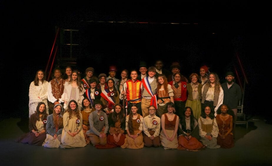students from teh production dressed in costumes from 19th century france in the production of Les Miserables