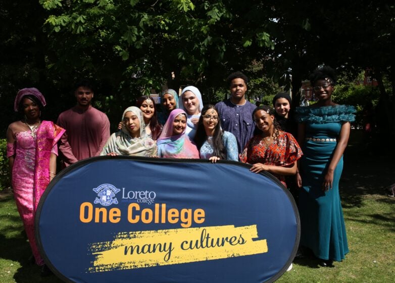 Loreto College students standing together outdoors with a banner reading ‘One College, many cultures’.