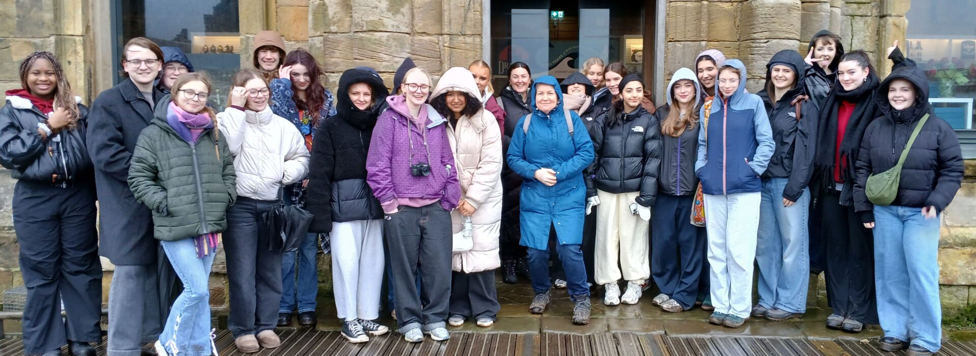 Group of Loreto College English students standing outside a historic stone building in Whitby during an educational visit.