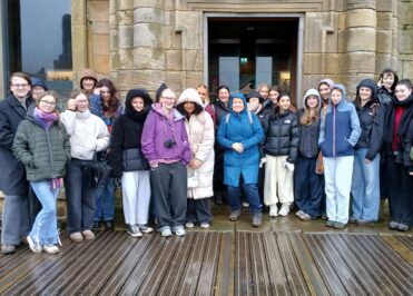 Group of Loreto College English students standing outside a historic stone building in Whitby during an educational visit.