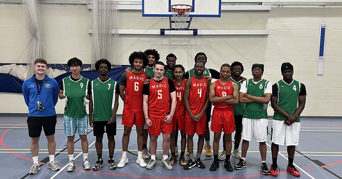 Loreto College basketball teams group photo in the Sports Hall wearing red and green kits