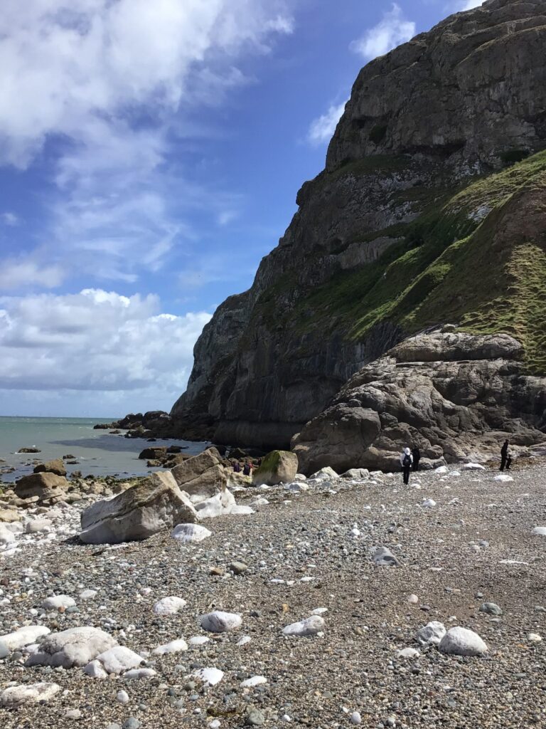 Large limestone cliffs and boulders on the shoreline beneath the Great Orme in Llandudno.